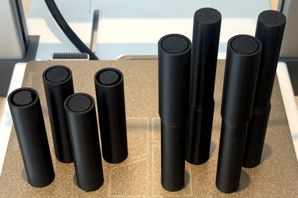 Final upper and lower 3D-printed connectors arranged in two groups on the printer bed.